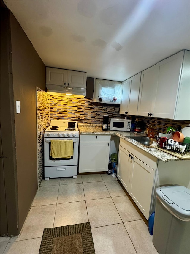 146 Grand Blvd, Brentwood, NY 11717 - kitchen with white appliances, under cabinet range hood, decorative backsplash, and light tile patterned flooring