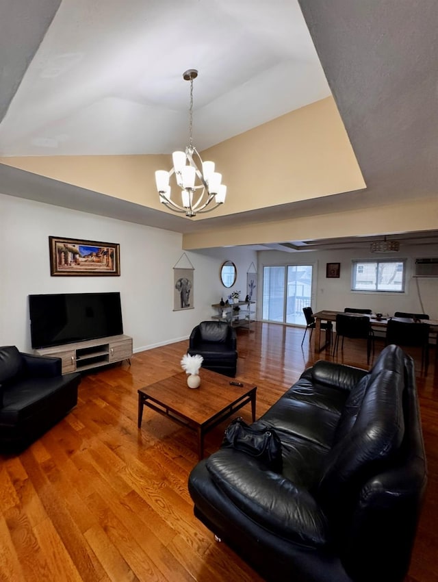 146 Grand Blvd, Brentwood, NY 11717 - living area featuring a chandelier, wood finished floors, a wall mounted AC, vaulted ceiling, and baseboards