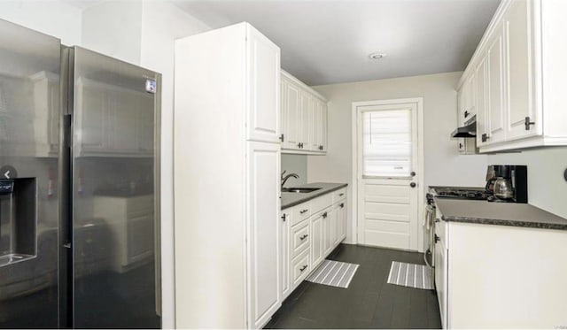 146 Grand Blvd, Brentwood, NY 11717 - kitchen with appliances with stainless steel finishes, dark countertops, white cabinetry, and under cabinet range hood