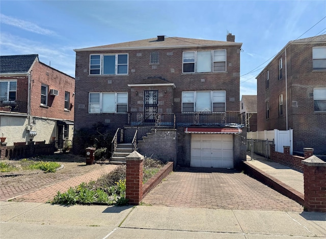 1208 Astor Ave, Bronx, NY 10469 - view of front facade with brick siding, a garage, decorative driveway, and a chimney