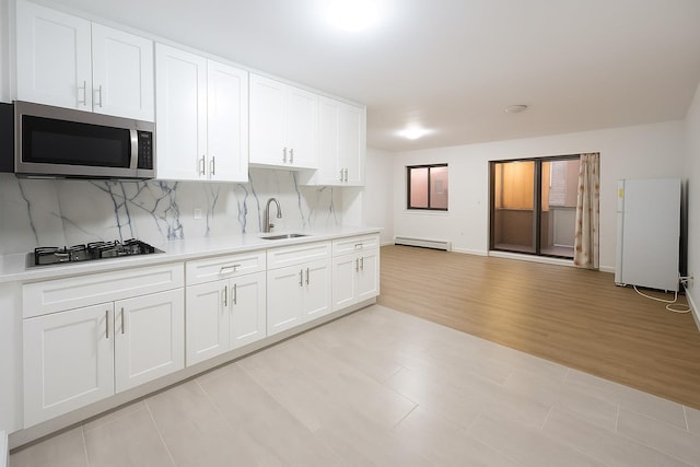 140-37 Cherry Unit 5C, Flushing, NY 11355 - kitchen with appliances with stainless steel finishes, a sink, light countertops, white cabinets, and a baseboard radiator