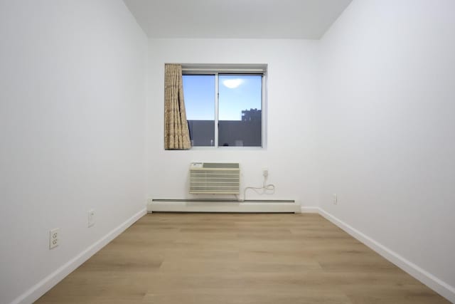 140-37 Cherry Unit 5C, Flushing, NY 11355 - empty room featuring a baseboard heating unit, baseboards, wood finished floors, and a wall mounted AC