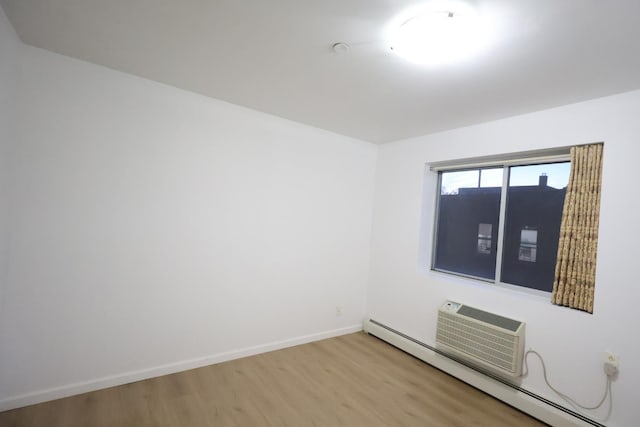 140-37 Cherry Unit 5C, Flushing, NY 11355 - empty room featuring a baseboard radiator, wood finished floors, baseboards, and a wall mounted AC
