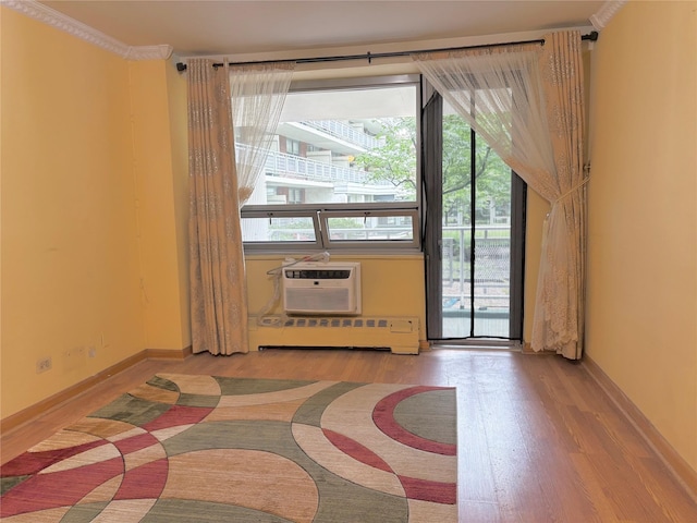 61-15 97th St Unit Ll, Rego Park, NY 11374 - unfurnished room featuring light wood finished floors, baseboard heating, a wall mounted AC, and baseboards