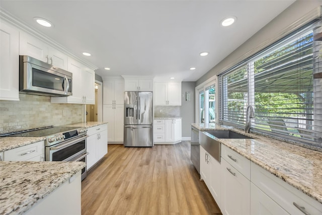 5 Firwood Dr, Farmingville, NY 11738 - kitchen with appliances with stainless steel finishes, a sink, white cabinetry, backsplash, and light wood-type flooring