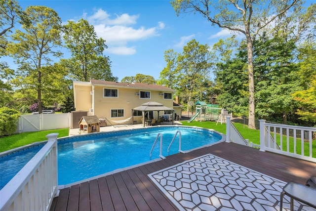 5 Firwood Dr, Farmingville, NY 11738 - view of pool featuring a wooden deck, a playground, a gazebo, view of wooded area, and a patio area