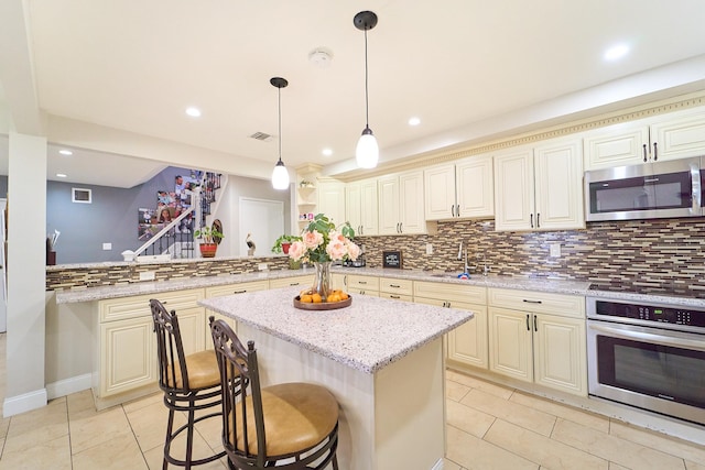 2 Hawthorne St, Farmingdale, NY 11735 - kitchen with stainless steel appliances, a sink, cream cabinetry, and recessed lighting