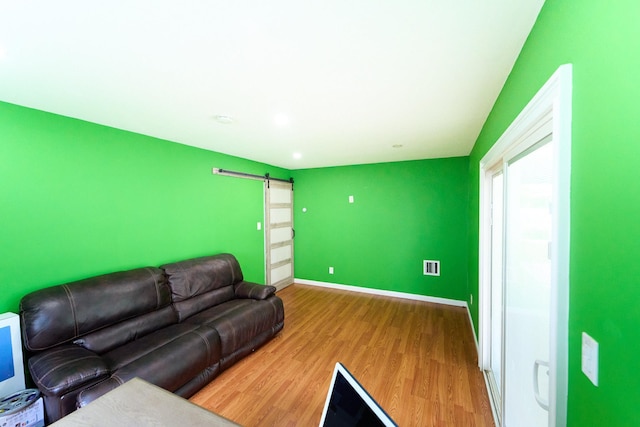 2 Hawthorne St, Farmingdale, NY 11735 - living area with a barn door, wood finished floors, and baseboards