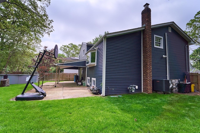 2 Hawthorne St, Farmingdale, NY 11735 - rear view of property featuring central air condition unit, a patio, and a chimney