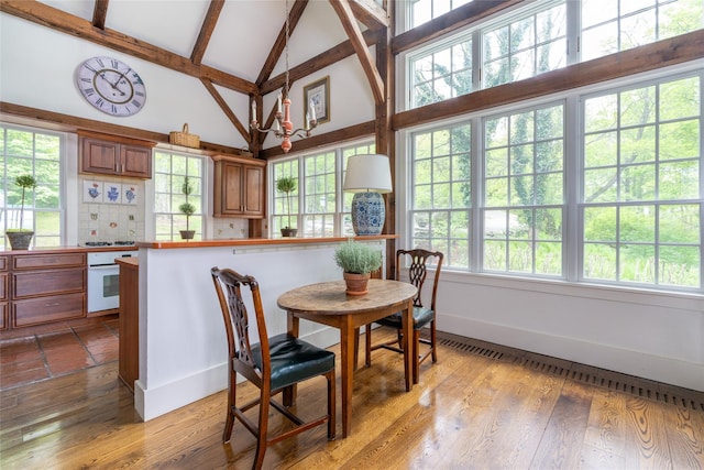 139 Charlie Hill Rd, Millerton, NY 12546 - dining area featuring high vaulted ceiling, plenty of natural light, beamed ceiling, baseboards, and wood finished floors