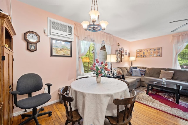 397 Mine Rd, Monroe, NY 10950 - living room featuring a chandelier, light wood-style flooring, a wall mounted AC, baseboards, and ceiling fan