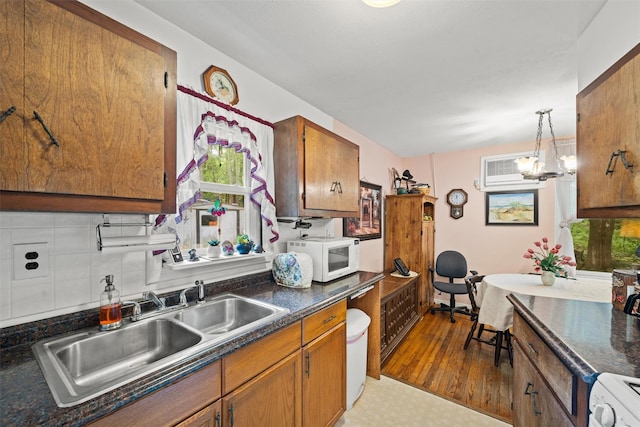 397 Mine Rd, Monroe, NY 10950 - kitchen with white microwave, a sink, brown cabinetry, dark countertops, and range