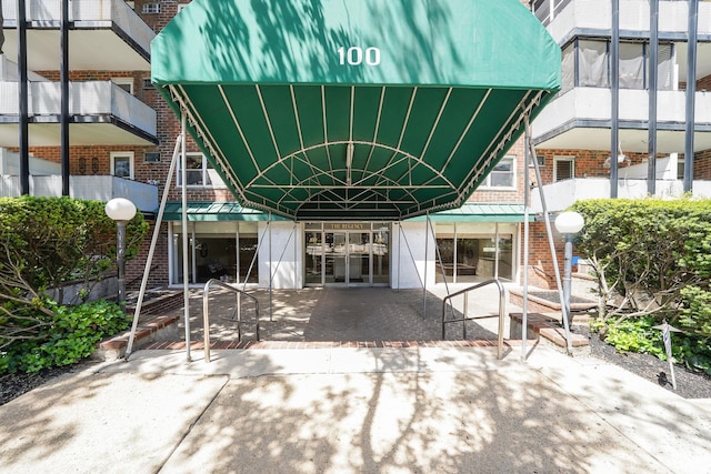 100 Lincoln Ave Unit 28C, Mineola, NY 11501 - back of property with brick siding, metal roof, a standing seam roof, and a patio