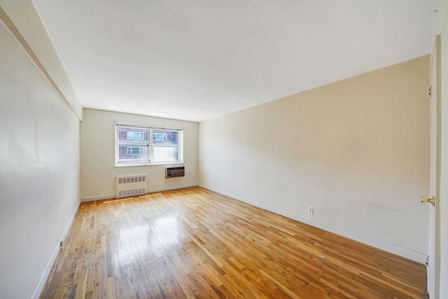 100 Lincoln Ave Unit 28C, Mineola, NY 11501 - empty room with radiator, light wood-style floors, baseboards, and a wall mounted AC