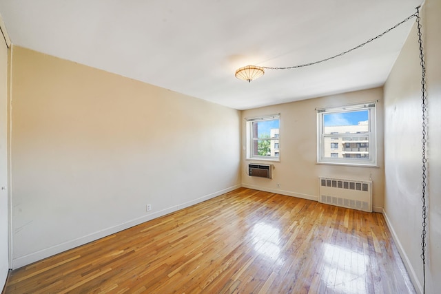 100 Lincoln Ave Unit 28C, Mineola, NY 11501 - spare room featuring radiator, light wood-style floors, baseboards, and a wall unit AC