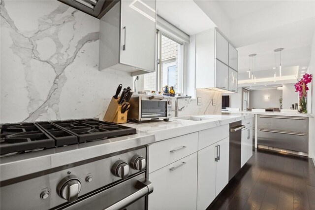 205 E 63rd St Phe, Phe New York Manhattan, NY 10065 - kitchen featuring appliances with stainless steel finishes, light countertops, white cabinets, and backsplash