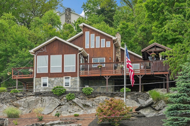 49 Brook Trl, Greenwood Lake, NY 10925 - rear view of house with a deck, a chimney, and stone siding