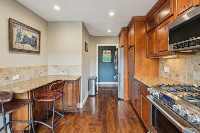 49 Brook Trl, Greenwood Lake, NY 10925 - kitchen with appliances with stainless steel finishes, light stone counters, dark wood-type flooring, brown cabinets, and recessed lighting