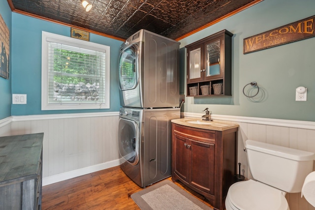 49 Brook Trl, Greenwood Lake, NY 10925 - bathroom featuring stacked washer / drying machine, an ornate ceiling, a wainscoted wall, wood finished floors, and crown molding