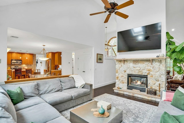 1138 Carlls Straight Path, Dix Hills, NY 11746 - living room featuring a ceiling fan, high vaulted ceiling, baseboards, dark wood-type flooring, and a stone fireplace