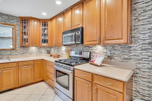 1138 Carlls Straight Path, Dix Hills, NY 11746 - kitchen featuring stainless steel appliances, light tile patterned floors, decorative backsplash, light countertops, and glass insert cabinets