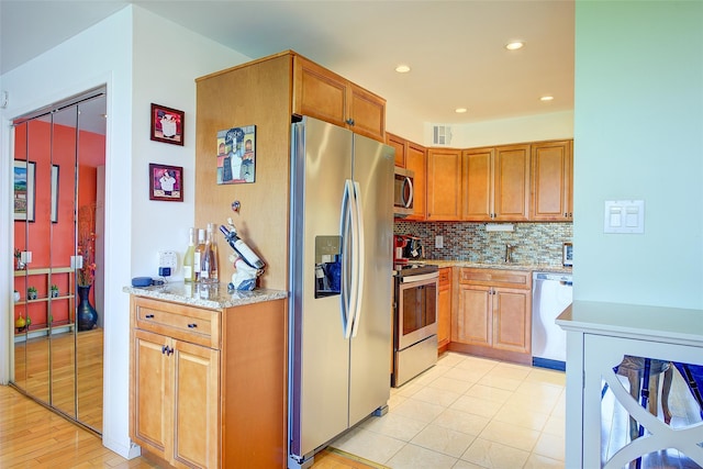 10-11 162nd St Unit 7A, Beechhurst, NY 11357 - kitchen with appliances with stainless steel finishes, backsplash, light stone countertops, light wood finished floors, and recessed lighting