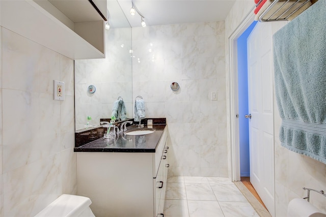 10-11 162nd St Unit 7A, Beechhurst, NY 11357 - bathroom featuring tile walls, vanity, marble look tiles, and toilet