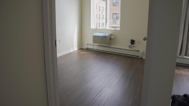 355 Kings Hwy Unit 5C, Brooklyn, NY 11223 - spare room featuring a baseboard radiator, dark wood-type flooring, an AC wall unit, and baseboards