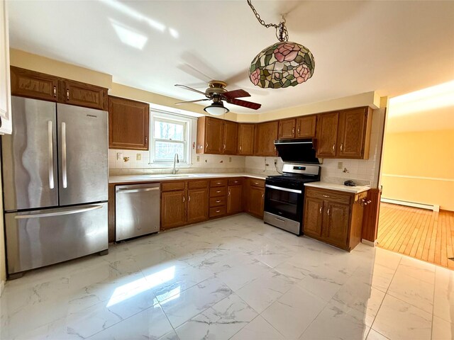 118 White Brg, Middletown, NY 10940 - kitchen featuring appliances with stainless steel finishes, baseboard heating, a sink, light marble finish flooring, and light countertops