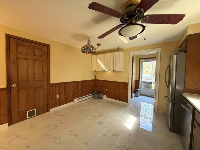 118 White Brg, Middletown, NY 10940 - kitchen with stainless steel appliances, wooden walls, a wainscoted wall, a baseboard heating unit, and light marble finish flooring