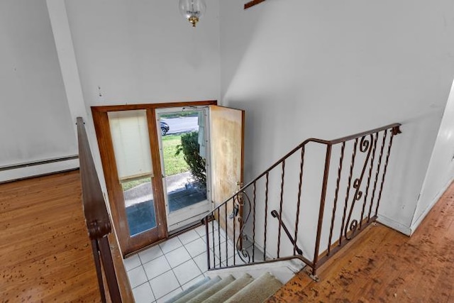 10 Lisa Dr, Northport, NY 11768 - stairs featuring wood finished floors, a baseboard heating unit, and a high ceiling