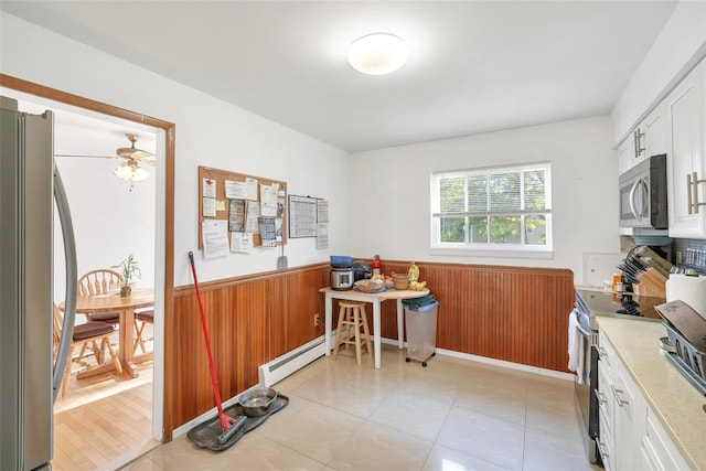 19 Decker Dr, Washingtonville, NY 10992 - kitchen with appliances with stainless steel finishes, wainscoting, white cabinetry, light countertops, and wooden walls