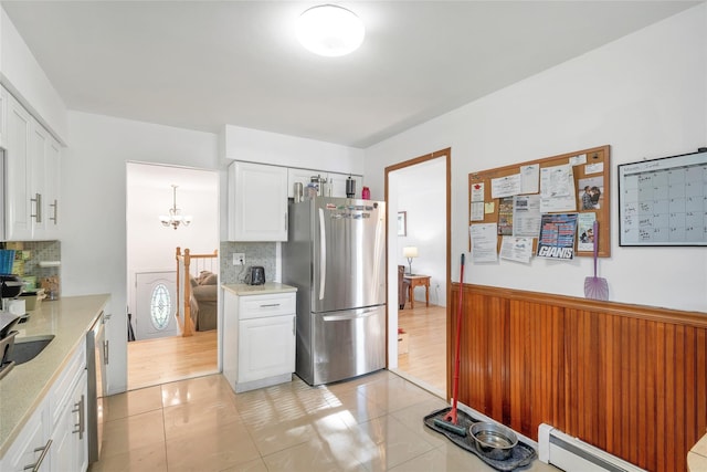 19 Decker Dr, Washingtonville, NY 10992 - kitchen with stainless steel appliances, baseboard heating, backsplash, white cabinetry, and light tile patterned floors