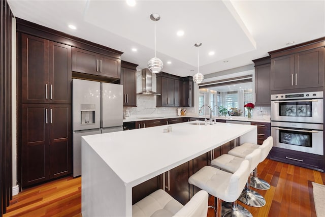 3 Deb St, Plainview, NY 11803 - kitchen with appliances with stainless steel finishes, wall chimney exhaust hood, a sink, tasteful backsplash, and a tray ceiling