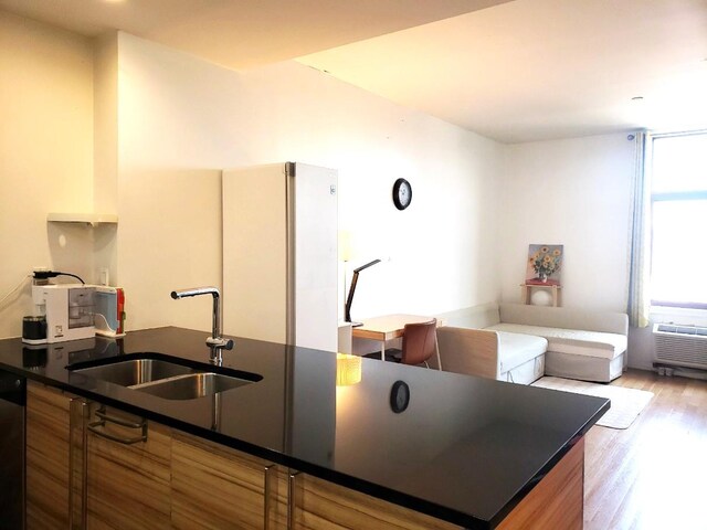 2311 21st Ave Unit 3C, Astoria, NY 11105 - kitchen with a sink, dark countertops, dishwasher, and wood finished floors