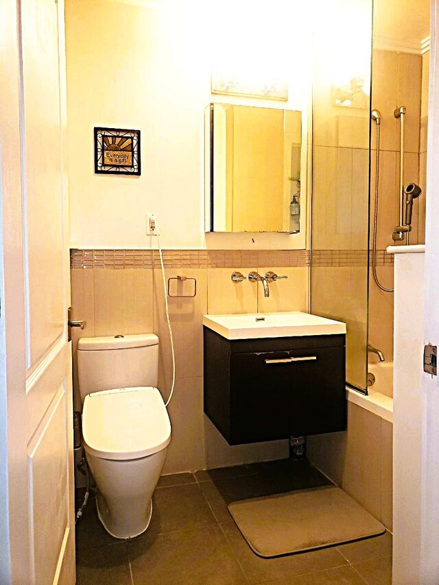 2311 21st Ave Unit 3C, Astoria, NY 11105 - full bath with tile walls, vanity, tile patterned floors, tiled shower / bath, and toilet