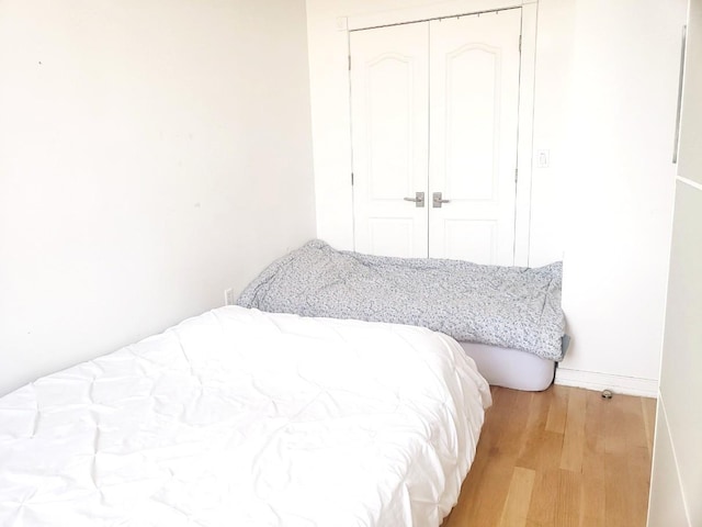 2311 21st Ave Unit 3C, Astoria, NY 11105 - bedroom featuring a closet, light wood-style flooring, and baseboards