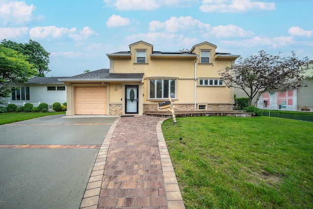 5 Forest Rd, Valley Stream, NY 11581 - view of front of home featuring stucco siding, driveway, an attached garage, solar panels, and stone siding