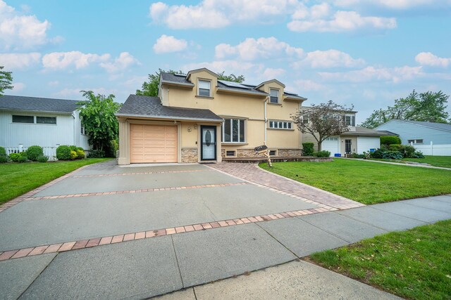 5 Forest Rd, Valley Stream, NY 11581 - traditional-style home featuring stucco siding, driveway, a garage, a front lawn, and solar panels