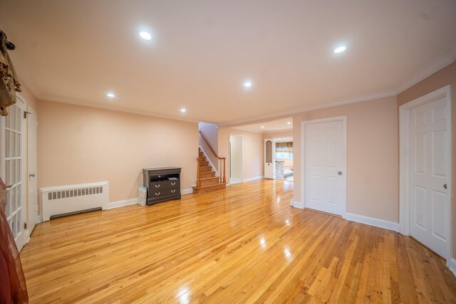 5 Forest Rd, Valley Stream, NY 11581 - unfurnished living room with radiator heating unit, crown molding, stairs, light wood finished floors, and recessed lighting