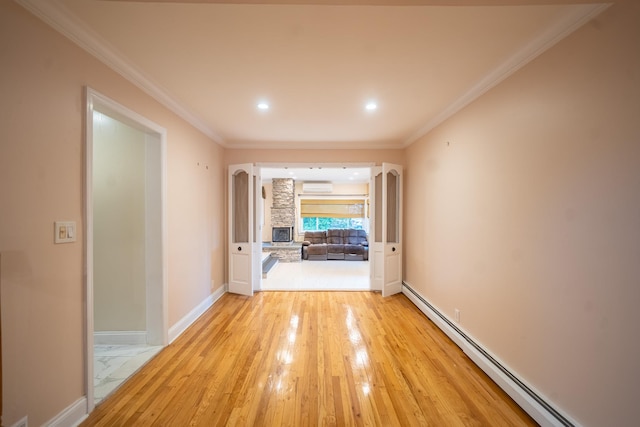 5 Forest Rd, Valley Stream, NY 11581 - unfurnished room featuring a baseboard heating unit, a wall unit AC, ornamental molding, baseboards, and light wood finished floors