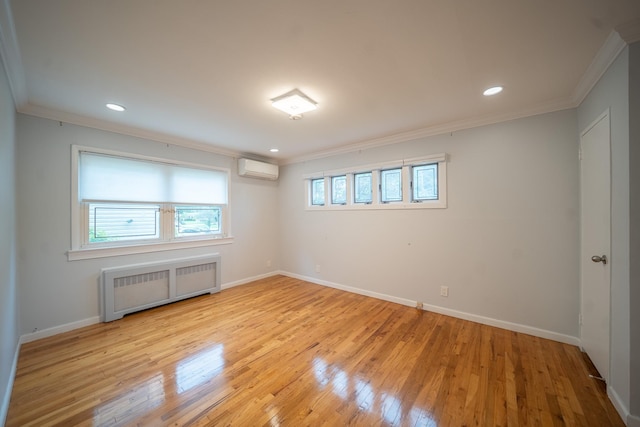 5 Forest Rd, Valley Stream, NY 11581 - spare room featuring radiator heating unit, ornamental molding, a wall mounted air conditioner, light wood-style flooring, and baseboards