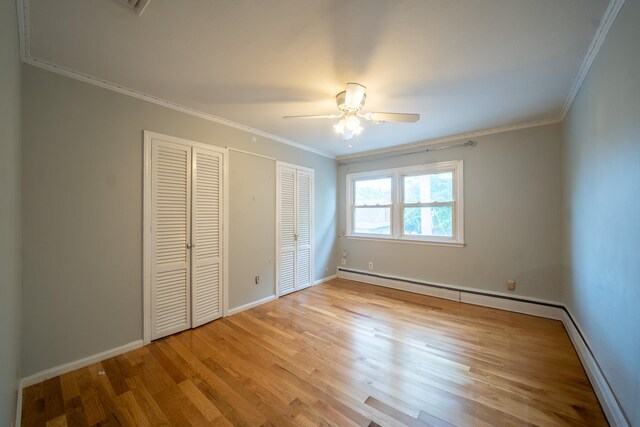 5 Forest Rd, Valley Stream, NY 11581 - unfurnished bedroom with crown molding, wood finished floors, baseboards, a ceiling fan, and a baseboard heating unit