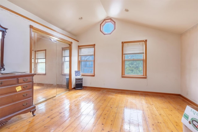 163 Cannon St, Poughkeepsie, NY 12601 - unfurnished bedroom with light wood-style floors, multiple windows, lofted ceiling, and a closet