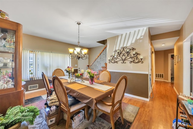 1623 Washington Ave, Bohemia, NY 11716 - dining room featuring a chandelier, wood finished floors, baseboards, and stairway