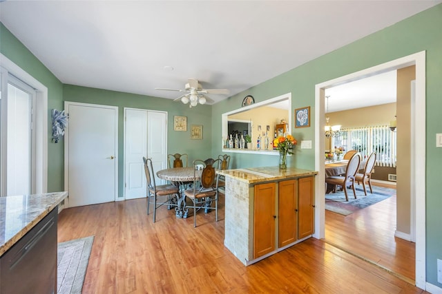 1623 Washington Ave, Bohemia, NY 11716 - kitchen featuring light wood finished floors, brown cabinets, a chandelier, light stone counters, and ceiling fan