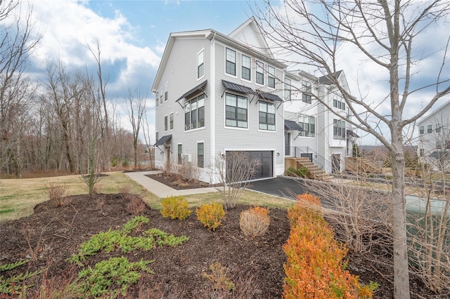 5 Brentwood Cir, Danbury, CT 06810 - view of side of property featuring asphalt driveway, an attached garage, and board and batten siding