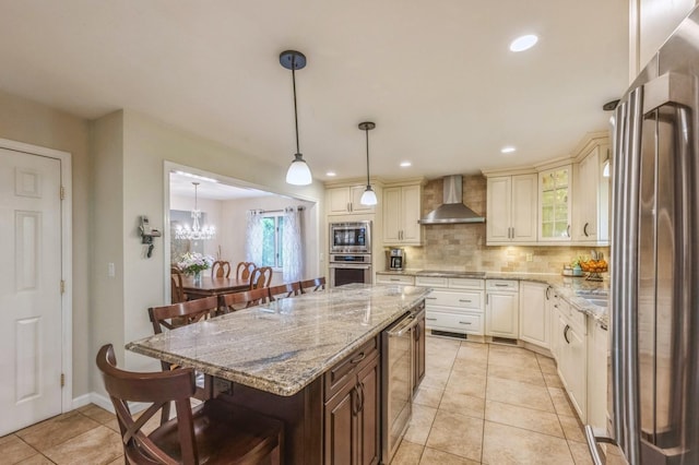 2 Caryl Pl, Kings Park, NY 11754 - kitchen with wall chimney range hood, stainless steel appliances, a kitchen bar, beverage cooler, and decorative backsplash
