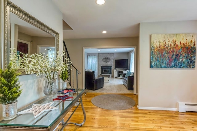 2 Caryl Pl, Kings Park, NY 11754 - foyer featuring a baseboard radiator, a fireplace, wood finished floors, baseboards, and recessed lighting