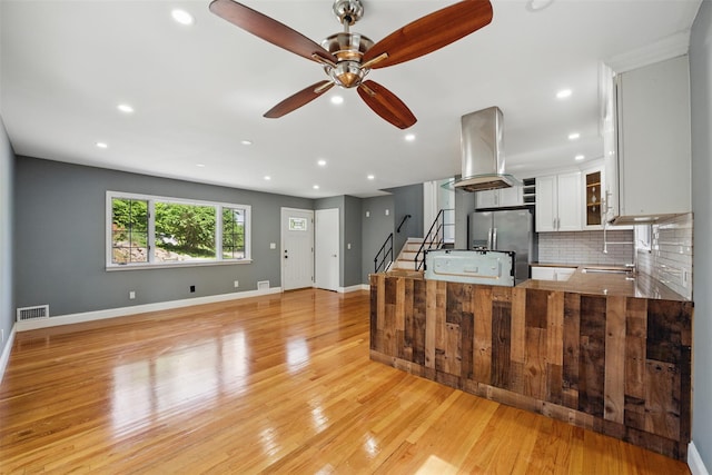 1 Renee Gate St, Cortlandt Manor, NY 10567 - kitchen featuring stainless steel fridge with ice dispenser, exhaust hood, backsplash, ceiling fan, and light wood-style floors
